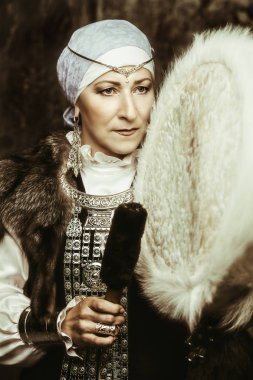 Yaşlı yerli kadın Ulusal kostüm antik müzik aleti çalıyor.