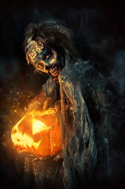 Cadılar Bayramı. Korkunç zombi gelini bir gece mezarlığı üzerinde bir balkabağı fener tutar. 