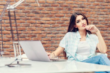 Bir masada oturan güzel bir bayan. Büro hayatı. İş yerinde.