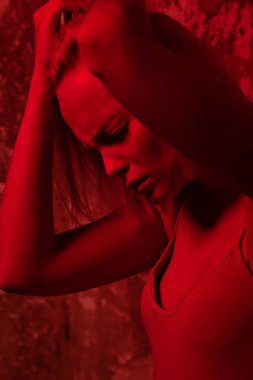 Ten rengi elbise kırmızı ışık Studio poz çekici genç kadın. Güzellik, moda.