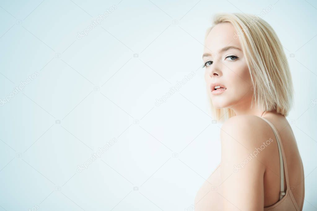Close-up portrait of a beautiful blonde woman with nude makeup over white background. Beauty, fashion concept. Make-up and cosmetics. Haircuts for short hair.
