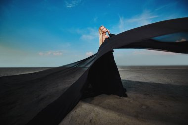 Tam uzunlukta portre güzel bir Gotik kadının uzun siyah elbise poz açık. Güzellik, moda.