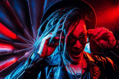 Portrait of a crazy disco man with dreadlocks. Party, disco. Colorful light. clipart