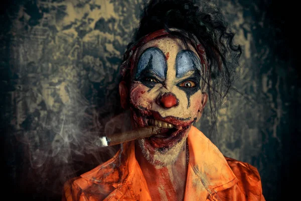 Cadılar Bayramı. İğrenç bir palyaço adam portresi koyu arka plan üzerinde kan lekeli. Erkek zombi palyaço. Korku, gerilim filmi.