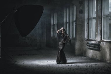 Güzel bir esmer Bayan harabelerde dans ediyor. Gece elbisesi. Moda, güzellik.