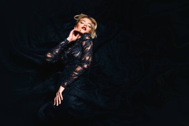 Güzel bir sarışın Bayan yerde yatıyor. Gece elbisesi. Moda, güzellik.