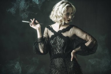 Güzel bir sarışın Bayan sigara içiyorum. Gece elbisesi. Moda, güzellik.