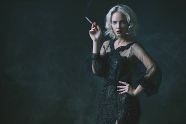 Güzel bir sarışın Bayan sigara içiyorum. Gece elbisesi. Moda, güzellik.