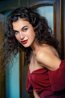 Genç kadın büyüleyici bir şehir sokak üzerinde zarif bordo elbise giymiş. Güzellik, moda kavramı. Kozmetik ve makyaj.