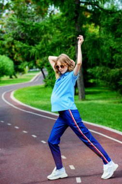 Hamile kadın parkta egzersizleri yapıyor. Gebelik. Sağlıklı yaşam tarzı.