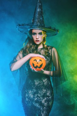 Balkabağına tutan cadı kostüm güzel bir bayan. Cadılar Bayramı. Kutlama.