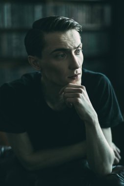 Yakın çekim yakışıklı bir dalgın genç adam bir odada portresi. Erkek güzellik ve sağlık.