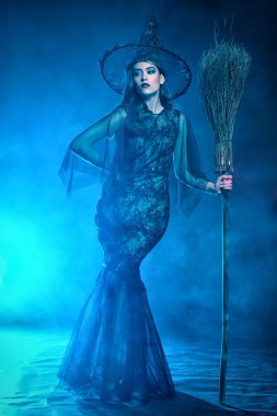 Bir süpürge tutan cadı kostüm güzel bir bayan. Cadılar Bayramı. Kutlama.