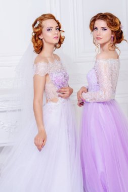 Sevimli gelin ve nedime birlikte güzel elbiseler ve gülümseme bekletin. Düğün moda. 