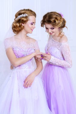 Sevimli gelin ve nedime birlikte güzel elbiseler ve gülümseme bekletin. Düğün moda. 