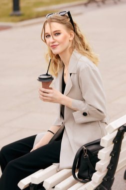 Deri ceketli güzel genç kadın sokakta oturuyor. İlkbahar ve sonbahar moda.