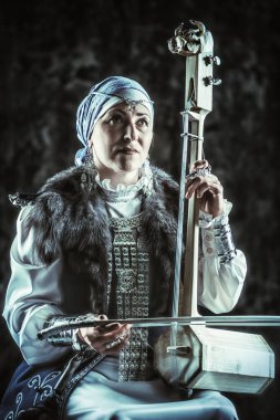 Ulusal kostüm yaşlı yerli kadın eski keman çalıyor.