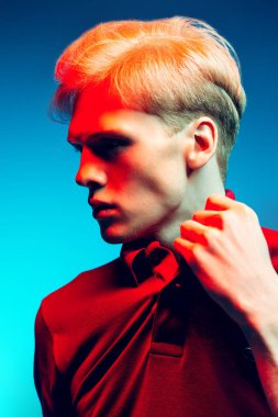 Yakın çekim portre sarışın saç stüdyoda ışık arka plan üzerinde poz ile yakışıklı bir genç adam. Erkek güzellik ve sağlık.