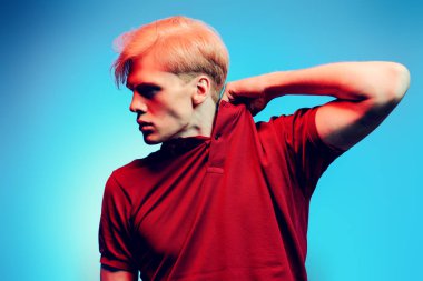 Yakın çekim portre sarışın saç stüdyoda ışık arka plan üzerinde poz ile yakışıklı bir genç adam. Erkek güzellik ve sağlık.