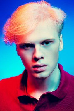 Yakın çekim portre sarışın saç stüdyoda ışık arka plan üzerinde poz ile yakışıklı bir genç adam. Erkek güzellik ve sağlık.