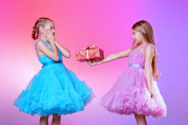 Festival elbise oldukça başka bir şık küçük kız bir hediye verir. güzel giyinmiş bir güzel kız.