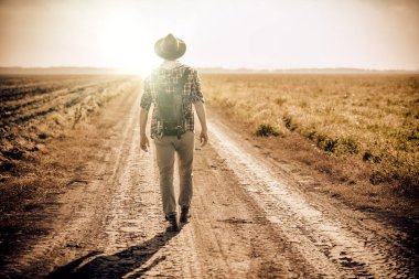 Uzak kırsal kesimde yolda yürüyen bir adam tam uzunlukta fotoğrafını. Moda Erkekler için. Rahat, rahat kıyafetler.