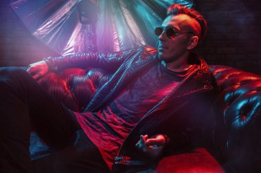 Çılgın disko adam kanepede yatıyor. Parti, disko. Renkli ışık.