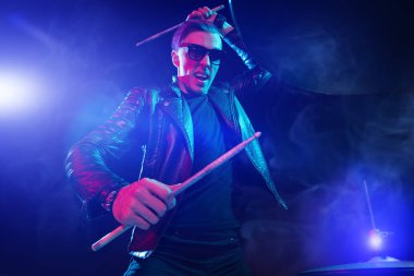 A crazy man is playing the drums in a dark room. Party, disco. Musical instrument. clipart