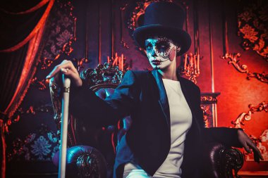 A lady wearing a tux in interior. Sugar skull makeup. Halloween. clipart
