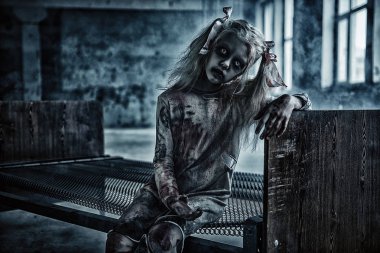 Bir yatakta bir korkutucu sarışın zombi kız portresi. Cadılar Bayramı. Korku filmi.