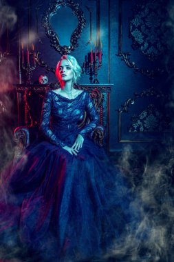Bir güzel vampir kadın karanlık bir odada oturuyor. Klasik tarzı. Güzellik, moda.