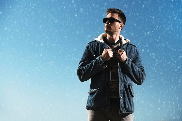 A handsome brutal man wearing a jacket and sunglasses. Fashion for men. Autumn, winter.