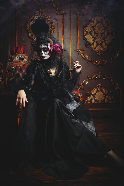 Calavera Catrina sitting in interior. Sugar skull makeup. Dia de los muertos. Day of The Dead. Halloween.