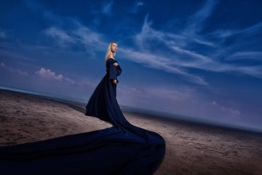 Tam uzunlukta portre güzel bir Gotik kadının uzun siyah elbise poz açık. Güzellik, moda.