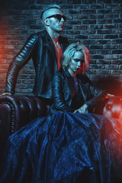 A beautiful couple of vampires in a dark room. Beauty, fashion.