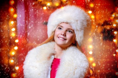 Bir kürk şapka ve atkı evinin yakınında güzel bir dokuz yaşındaki kız portresi Noel için dekore edilmiştir..