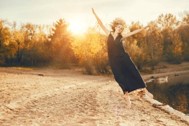 Dışarıda siyah elbiseli güzel bir genç kız poz veriyor. Moda konsepti.