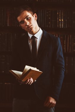 Şık giysileriyle kütüphanede duran akıllı öğrenci çocuk. Moda. Eğitim kavramı.