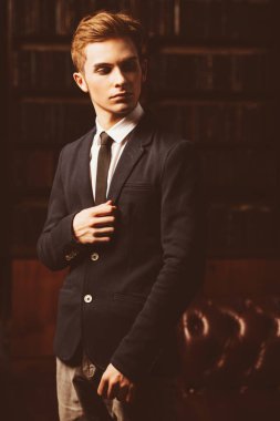 Şık giysileriyle kütüphanede duran akıllı öğrenci çocuk. Moda. Eğitim kavramı.