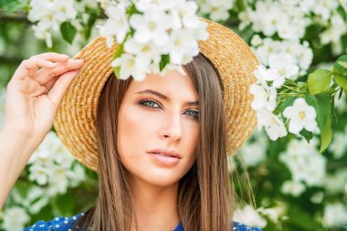 Bir çiçek bahçesinde poz hasır şapkalı güzel kız. Güzellik, moda.