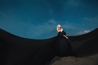 Tam uzunlukta portre güzel bir Gotik kadının uzun siyah elbise poz açık. Güzellik, moda.