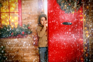Evden dışarı arayan küçük bir çocuk Noel için dekore edilmiştir. Mucize zamanı. Mutlu Noeller ve mutlu yeni yıl.