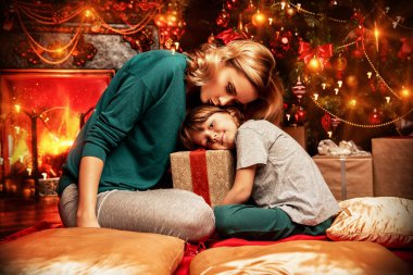 Anne ve oğlu Noel için dekore edilmiş ev altındadır. Aile mucize zamanı. Mutlu Noeller ve mutlu yeni yıl.