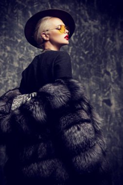 Çok güzel sarışın kadın lüks kürk manto ve şapka poz. Moda, güzellik. Stüdyo vurdu.