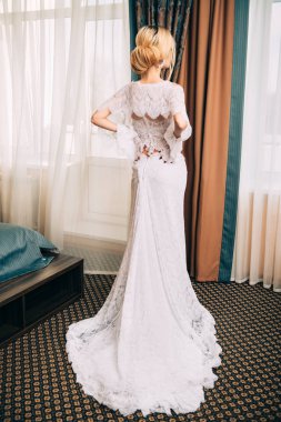 Tam uzunlukta zarif uzun elbise içinde muhteşem bir genç kadın portresi. Lüks daireler. Düğün moda.