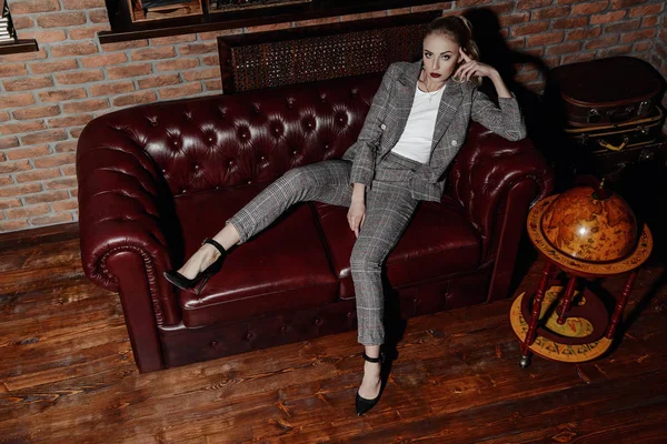 Sexy woman in a elegant suit posing in luxurious vintage interior. Full length portrait. Beauty, fashion.