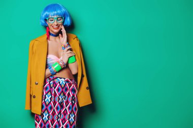 Yeşil arka plan üzerinde parlak yaz giysileri giyiyor mavi saçlı kız moda portre. Güzellik, moda kavramı. Pin-up tarzı.