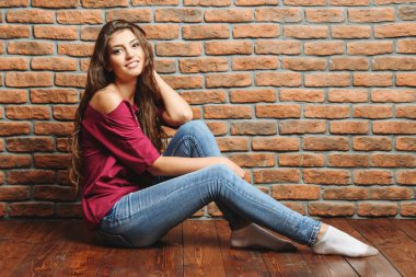 Bir tuğla duvar üzerinde çekici bir bayan. Portre. Doğal güzellik.