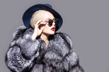 Çok güzel sarışın kadın lüks kürk manto ve şapka poz. Moda, güzellik. Stüdyo vurdu.