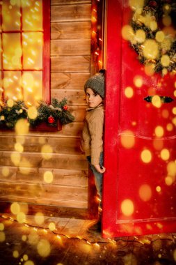 Evden dışarı arayan küçük bir çocuk Noel için dekore edilmiştir. Mucize zamanı. Mutlu Noeller ve mutlu yeni yıl.